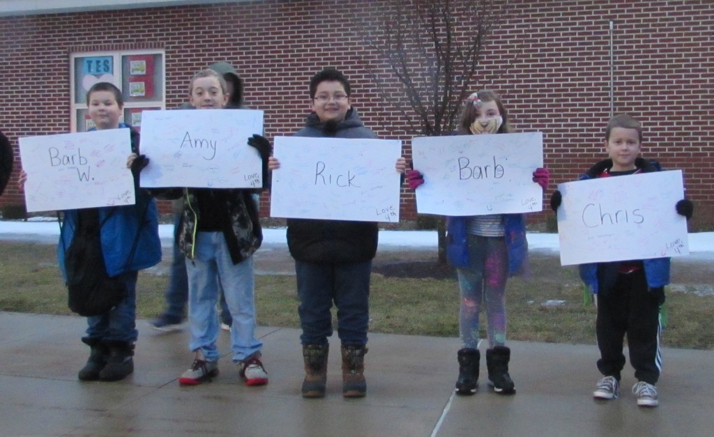 Students holding signs for bus drivers.